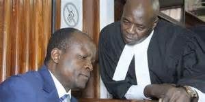 File photo- Okoth Obado consults his lawyer in court