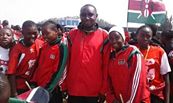 Kwale Girls' soccer team coach, Mukasa Amboko, poses with his players. The girls have won this year's SOYA awards