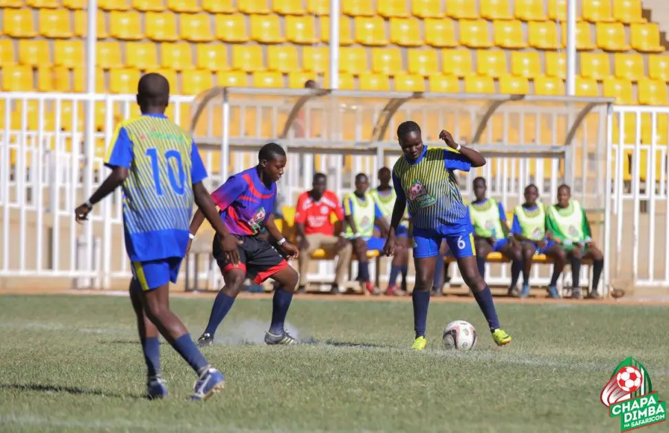 An Arch Bishop Njenga's player, in blue red stripped top, is sandwitched between two Ibinzo players in a during a pulsating girlrs' final in the Western Region 2019 Chapa Dimba na Safaricom. Arch Bishop Njenga won 2-0