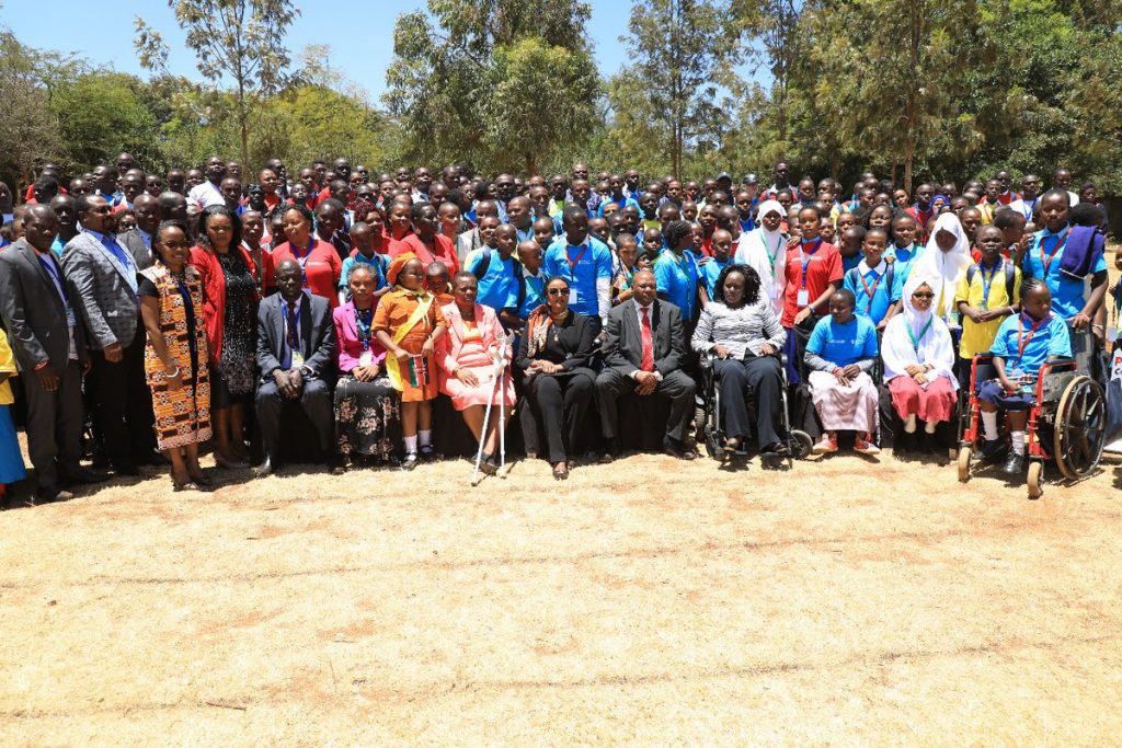 Education Cabinet Secretary, Dr Amina Mohammed; seated in front row and in a black attire plus spectacles , when she attended the 2nd Children Devolution Conference, that was held at Nairobi Primary School on Monday this week. Dr Amina says the 100 percent transition policy has led to congestion in high schools and wants MPs to help out in setting funds aside for construction of infrastructure.