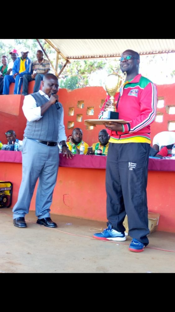 Kisii KUPPET Chairman Laban Bosire, right, poses with one of the trophies donated by the teachers' union leadership during this year's County Term One Championship. On the left is Kisii Sports Committee Secretary Nyantika Geoffrey.